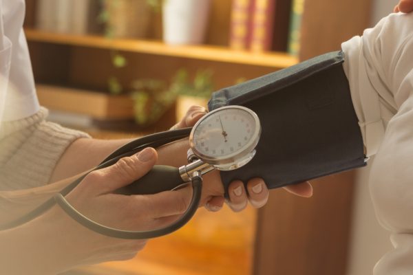 Patient during measuring blood pressure Older female patient when measuring pressure during home visit